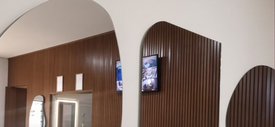 Ambiente com painéis ripados, arcos e espelho com LED